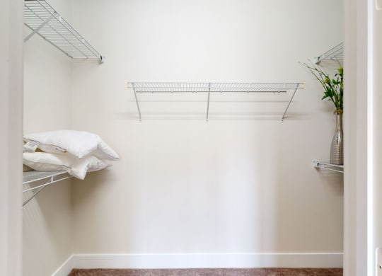 a walk in closet in a bedroom with white walls