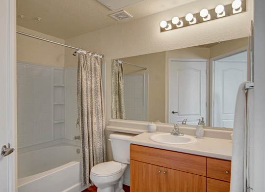 A bathroom with a white toilet, sink, and shower.