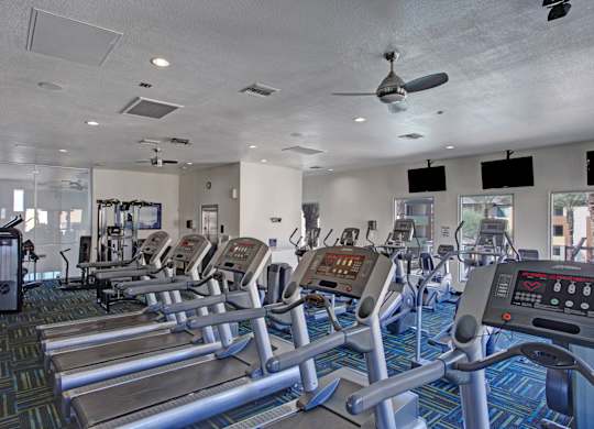 A gym with treadmills and other exercise equipment.
