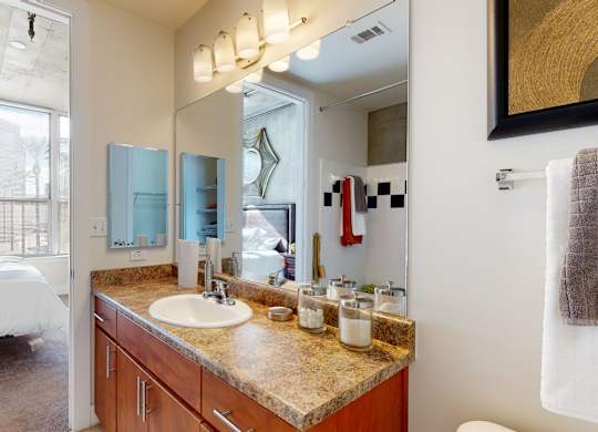 A bathroom with a large mirror and a sink.