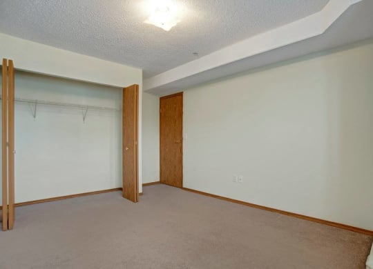 an empty room with a door to a closet