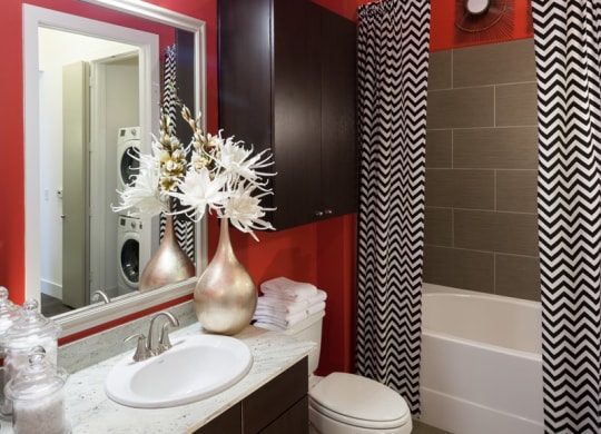 a bathroom with red walls and a sink and a toilet