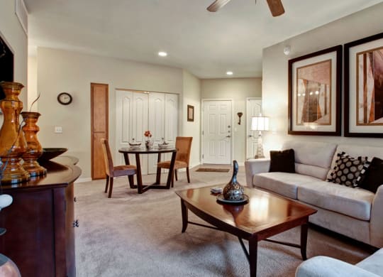 Cozy living room here at Bolero Apartments with cream sofas, patterned cushions, and two abstract artworks on the wall. A wooden coffee table and soft lighting create a warm ambiance.