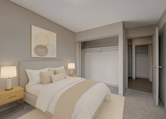 A cozy bedroom here at Cedar Gardens with soft neutral tones and a comfortable bed setup, featuring matching nightstands with warm lamps, simple wall art above the headboard, and a spacious closet area for an airy, relaxing feel.