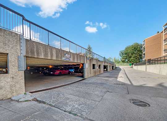 A convenient covered parking garage here at Gateway Square with clearly marked spaces, easy drive-in access, and open surroundings under a bright blue sky.