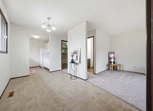 A room with a tiled floor and a chandelier hanging from the ceiling.