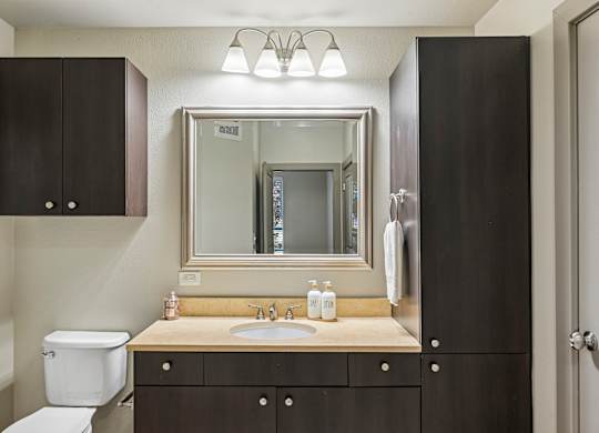 A bathroom with a sink, mirror, and toilet.