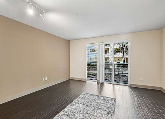 A room with a sliding glass door leading to a balcony.