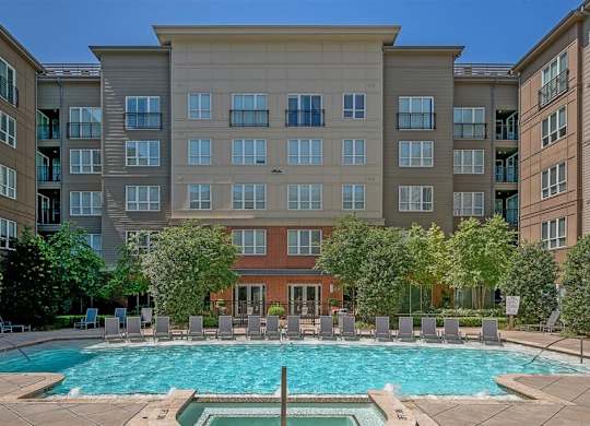 A large apartment complex with a pool in the foreground.