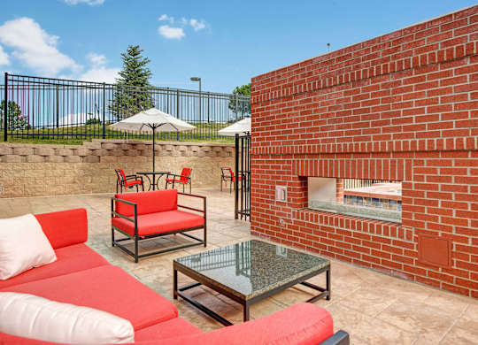 A red couch and table are on a patio.
