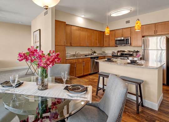 A modern kitchen with a dining table set for two.