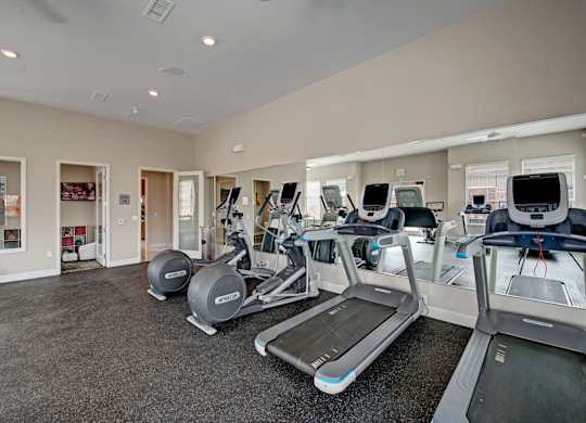 A gym with treadmills and elliptical machines.