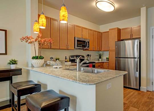 A kitchen with a counter and bar stools.