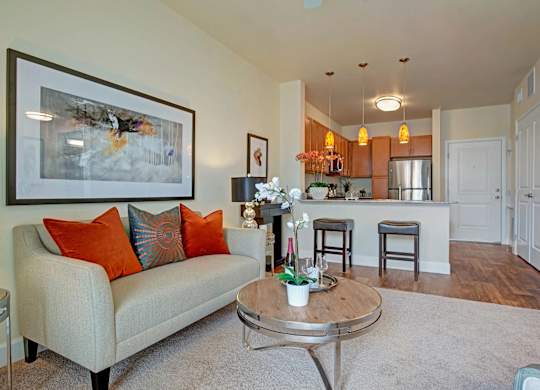 A living room with a couch, coffee table, and a painting on the wall.