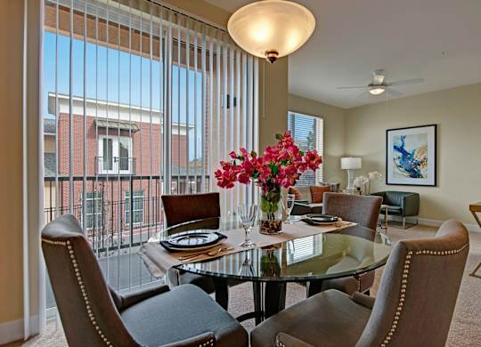 A dining room with a glass table and chairs.