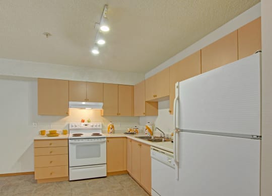 a kitchen with white appliances and wooden cabinets
