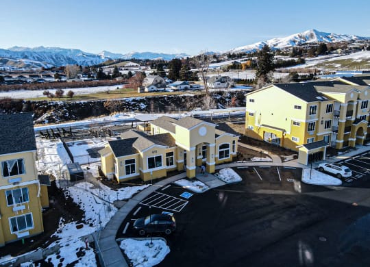 an aerial view of a row of houses with snow covered mountains in the background
