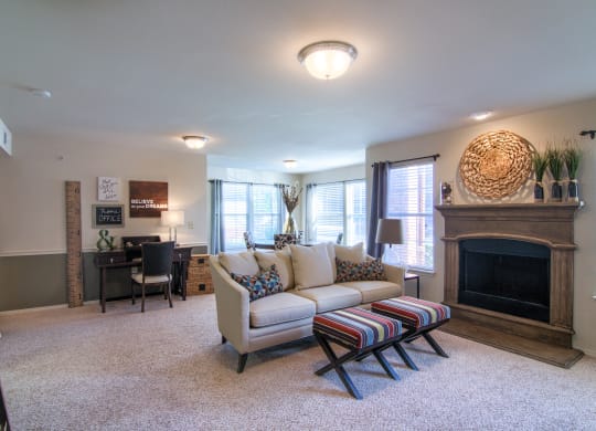 a living room with a couch and a chair in front of a fireplace