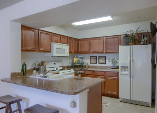 a kitchen with a granite counter top and wooden cabinets