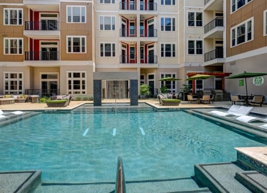 a large swimming pool in front of an apartment building