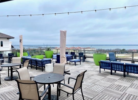 a deck with tables and chairs and a view of the ocean