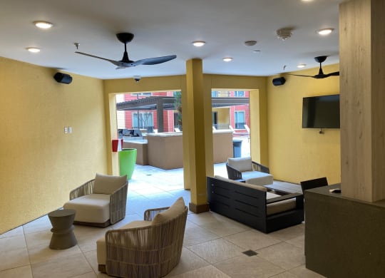 a lobby with chairs and a couch and a tv