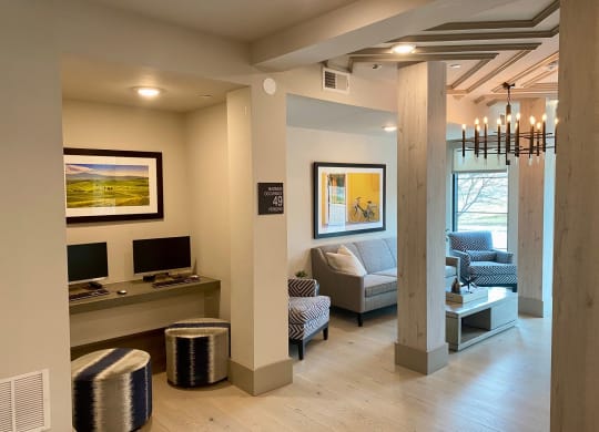 a living room with couches and a desk and a tv