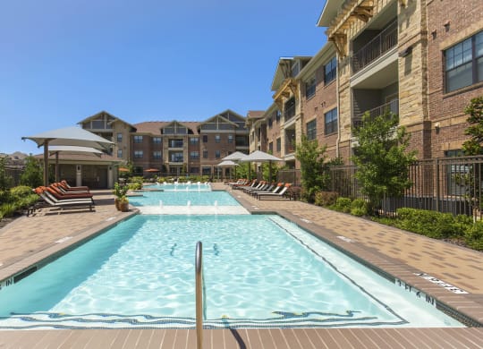 a large swimming pool in front of an apartment building