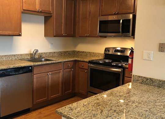 A kitchen with granite countertops and stainless steel appliances.