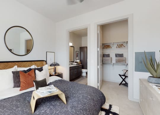 a bedroom with a large bed and a bathroom in the background