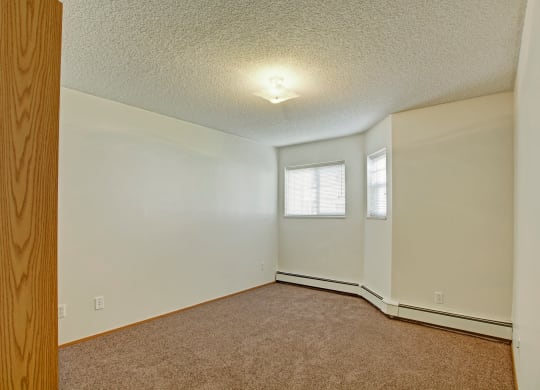 an empty living room with white walls and a window