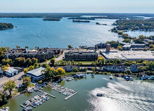 A marina with boats and buildings surrounded by trees.