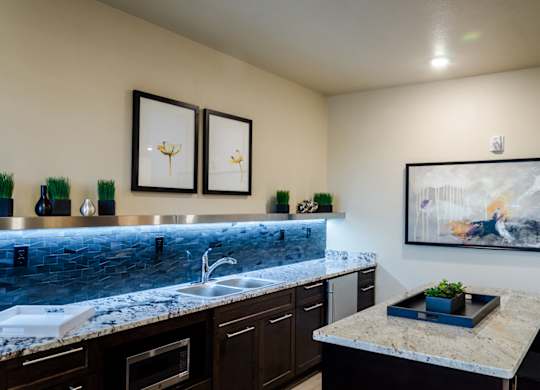 A kitchen with a marble countertop and a painting on the wall.