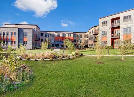 A grassy area in front of apartment buildings.