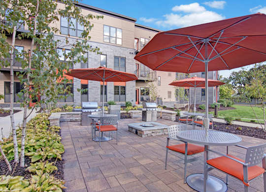 A patio with a table and chairs under an umbrella.