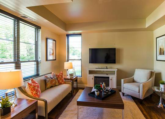 A living room with a couch, chair, and fireplace.