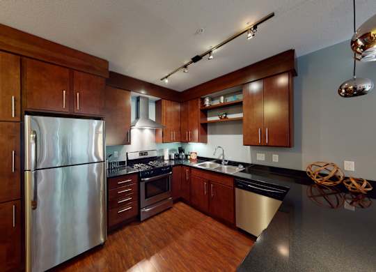 A modern kitchen with wooden cabinets and stainless steel appliances.