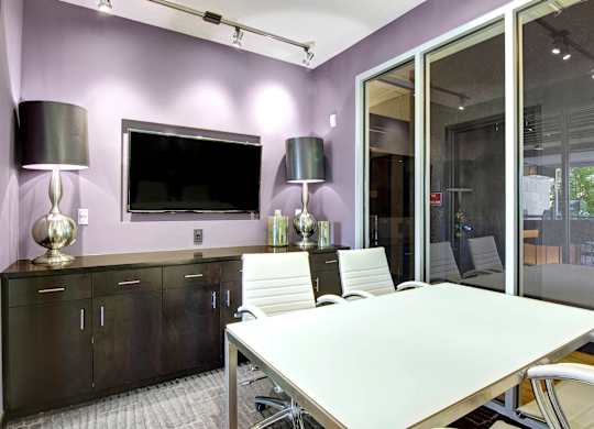 A conference room with a long table and chairs.