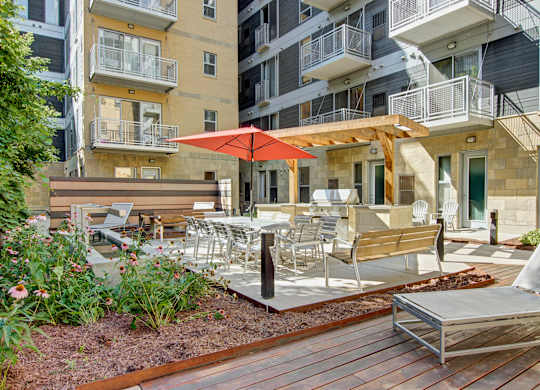 A patio with a table and chairs and an umbrella.