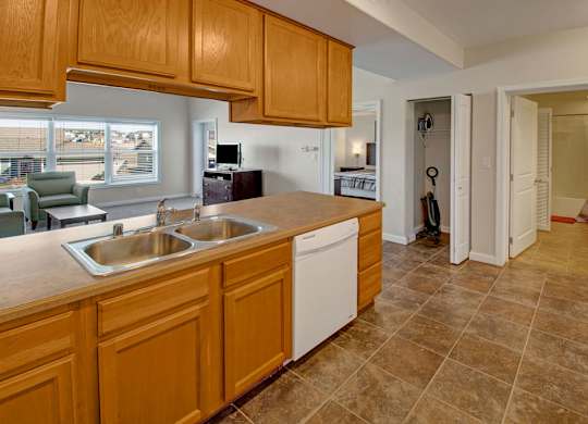 A kitchen with wooden cabinets and a tiled floor.