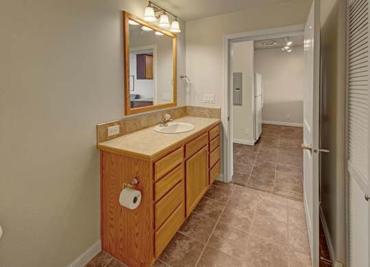 A bathroom with a sink, mirror, and toilet.