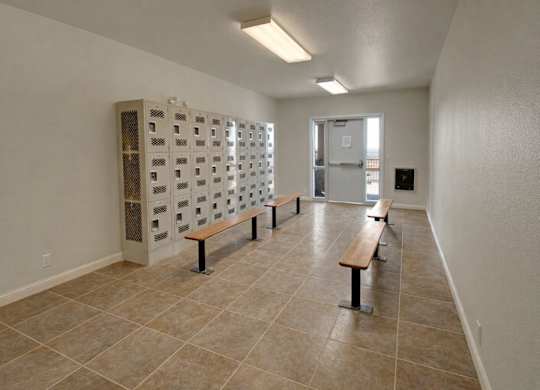 A room with a tiled floor and a row of benches.
