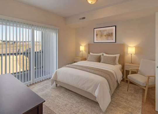 A bedroom with a large bed and a chair.