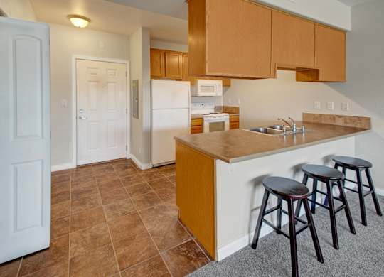 A kitchen with brown cabinets and a white refrigerator.
