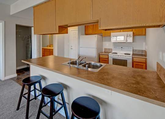 A kitchen with a white refrigerator, a white oven, and a white microwave.