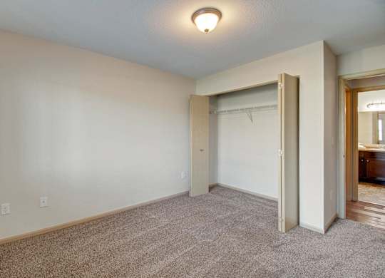 A room with a carpeted floor and a white wall with a light switch.