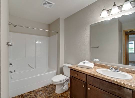 A bathroom with a toilet, sink, and bathtub.