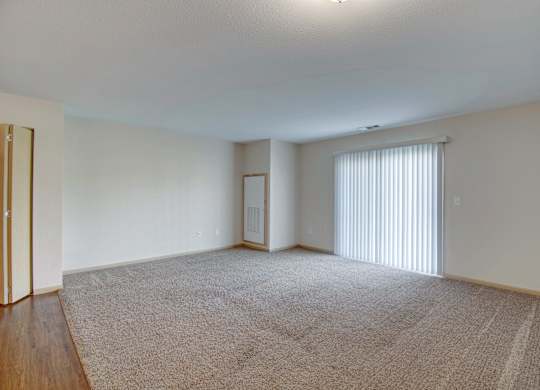 A carpeted room with a sliding glass door.