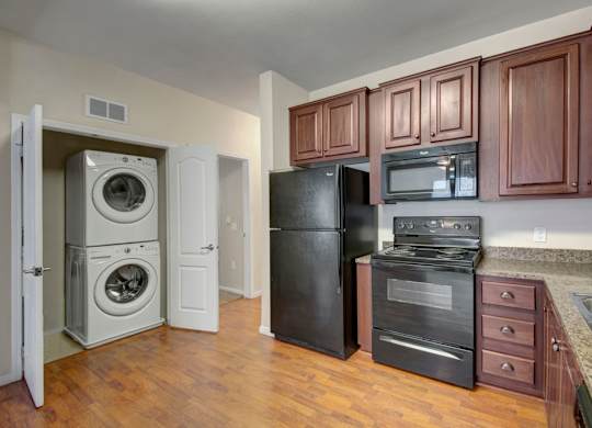 A kitchen with black appliances and wooden cabinets.