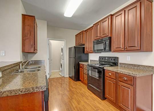 A kitchen with wooden cabinets and black appliances.
